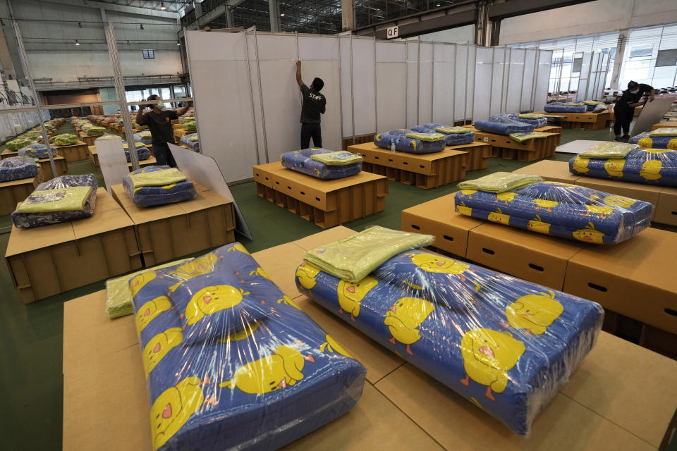 Workers install partition at field hospital set up inside a cargo building in Don Mueang International Airport in Bangkok, Thailand, Thursday, July 29, 2021. Health authorities raced on Thursday to set up yet another large field hospital in Thailand's capital as the country recorded a new high in COVID-19 cases and deaths. The hospital, one of many already in use, was being set up at one of Bangkok's two international airports after the capital ran out of hospital beds for thousands of infected residents. (AP Photo/Sakchai Lalit)