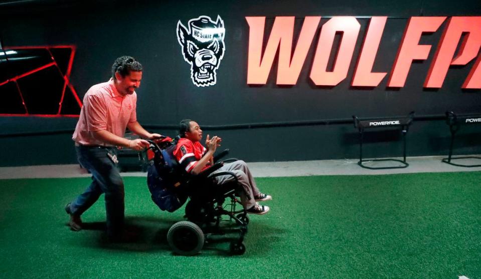 Savage Wolves NIL Co-Owner Tom Livolsi pushes Grayson Ketchie up towards the Murphy Center after watching the football team take the field before N.C. State’s game against Marshall at Carter-Finley Stadium in Raleigh, N.C., Saturday, Oct. 7, 2023.