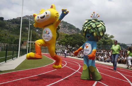 The unnamed mascots of the Rio 2016 Olympic (L) and Paralympic Games are pictured with the Morro dos Prazeres slum in the background during its presentation in Rio de Janeiro, November 24, 2014. REUTERS/Pilar Olivares