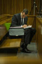 Oscar Pistorius makes notes as he sits in the dock during his trial in court in Pretoria, South Africa, Thursday, March 13, 2014. Pistorius is charged with the shooting death of his girlfriend Reeva Steenkamp, on Valentines Day in 2013. (AP Photo/Alet Pretorius, Pool)
