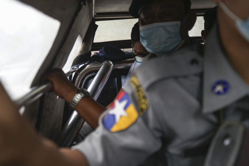 Canadian pastor David Lah, rear, is escorted by police to a township court for a hearing Thursday, Aug. 6, 2020, in Yangon, Myanmar. The court have sentenced Lah to three months imprisonment after finding him guilty of violating a law intended to combat the spread of the coronavirus. (AP Photo/Thein Zaw)