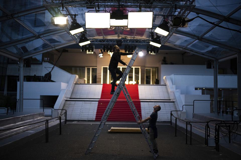 Trabajadores preparan la iluminación en la alfombra roja del Palais des Festivals previo al festival de cine de Cannes, en Cannes, sur de Francia, el domingo 14 de mayo de 2023. La 76a edición del festival de cine se realizará del 16 al 27 de mayo. (Foto AP/Daniel Cole)