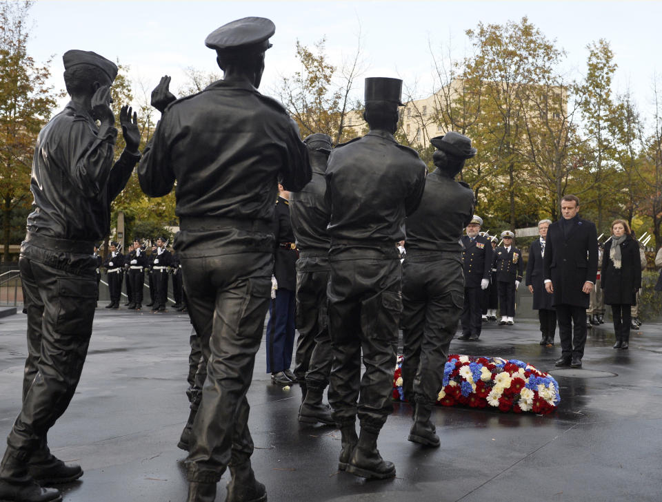 French President Emmanuel Macron inaugurates a memorial for soldiers fallen in foreign conflicts, Monday Nov. 11, 2019 in Paris. As part of commemorations marking 101 years since World War I's Armistice, French President Emmanuel Macron led a ceremony for the 549 French soldiers who died in 17 theaters of conflict since the 60s. The monument memorial depicts six soldiers _ five men and a woman _ holding up an invisible coffin. (Johanna Geron/Pool via AP)