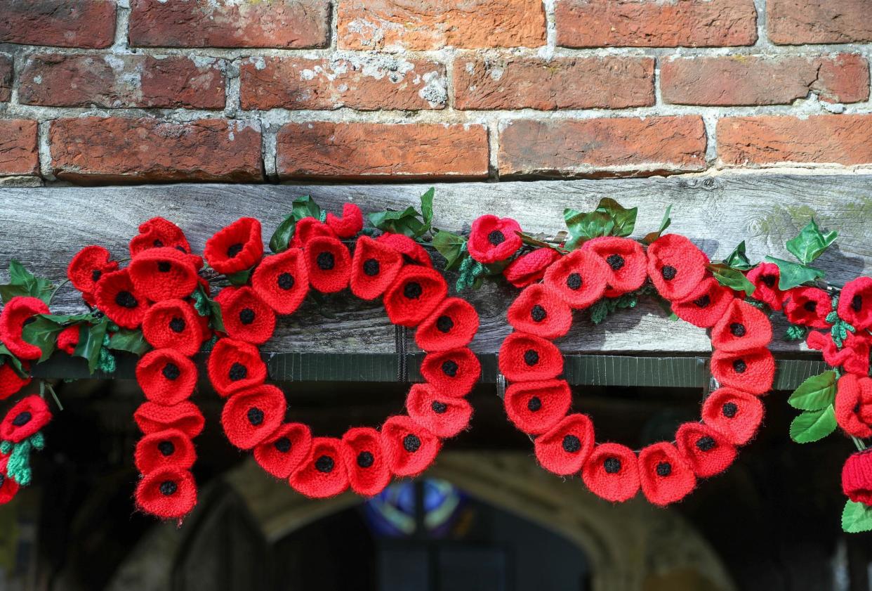 Knitted poppies form the number 100 over the doorway into St John the Baptist Church in North Baddesley, Hampshire (PA)