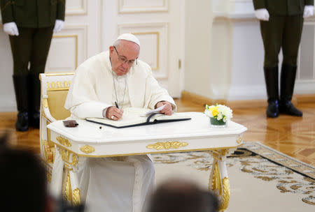 Pope Francis signs a guest book during his visit in Vilnius, Lithuania September 22, 2018. REUTERS/Ints Kalnins