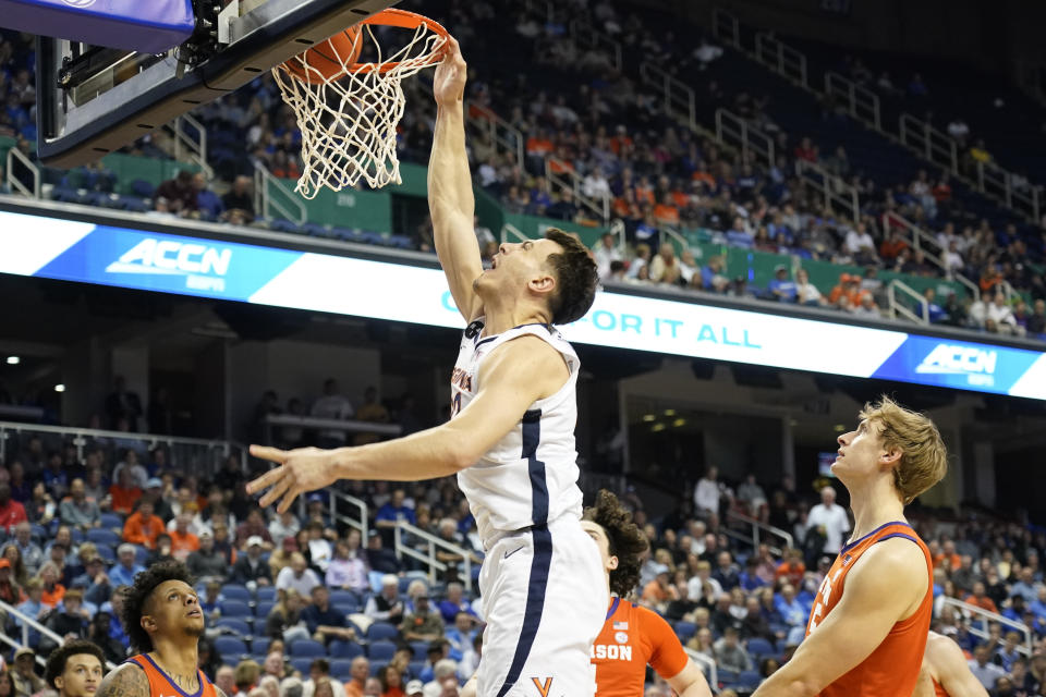 Virginia center Francisco Caffaro (22) dunks past Clemson forward Hunter Tyson (5) during the first half of an NCAA college basketball game at the Atlantic Coast Conference Tournament in Greensboro, N.C., Friday, March 10, 2023. (AP Photo/Chuck Burton)