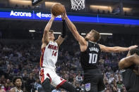 Miami Heat guard Tyler Herro (14) shoots over Sacramento Kings forward Domantas Sabonis (10) during the first quarter of an NBA basketball game in Sacramento, Calif., Saturday, Oct. 29, 2022. (AP Photo/Randall Benton)