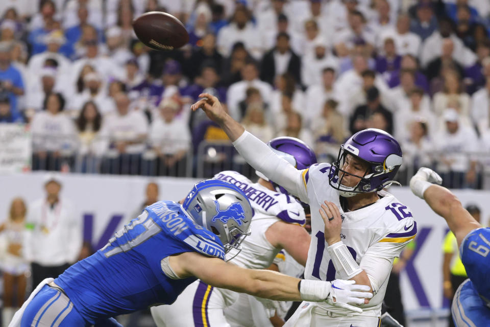 Minnesota Vikings quarterback Nick Mullens (12) passes as he is pressured by Detroit Lions defensive end Aidan Hutchinson (97) during the second half of an NFL football game, Sunday, Dec. 24, 2023, in Minneapolis. (AP Photo/Bruce Kluckhohn)