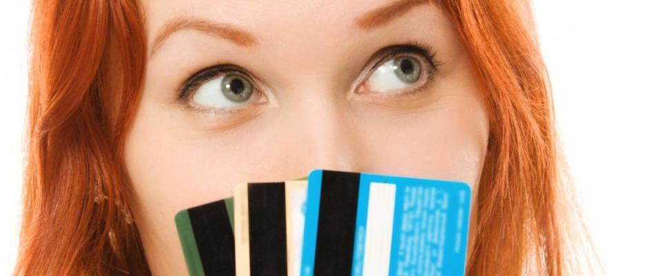 Woman with many different credit cards. Isolated on white.