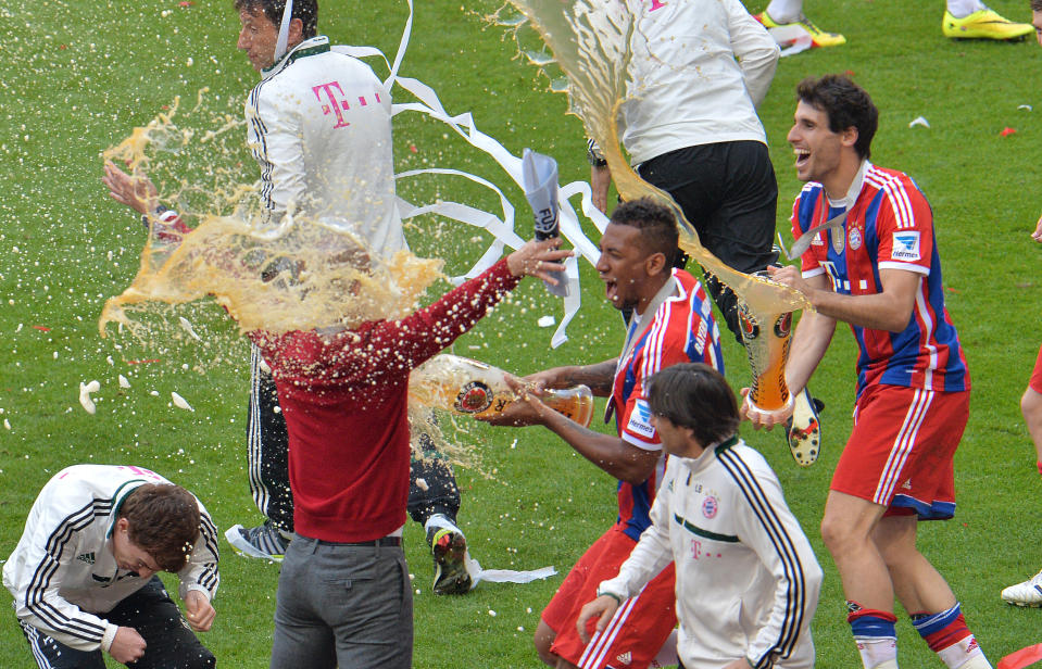 Bayern head coach Pep Guardiola of Spain, right, gets a shower of beer from Jerome Boateng, center, after Bayern Munich became the new Bundesliga champion after the German first division Bundesliga soccer match between FC Bayern Munich and VfB Stuttgart in the Allianz Arena in Munich, Germany, on Saturday, May 10. 2014. (AP Photo/Kerstin Joensson)