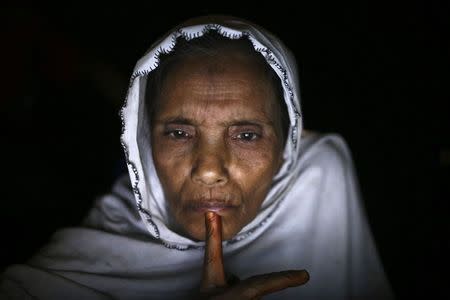 Norbanu, a 60-year-old Rohingya, speaks with her daughter's boyfriend, who is now in Indonesia, from an internet hut in Thae Chaung village, home to thousands of displaced Rohingya Muslims near Sittwe, the capital of Rakhine State in western Myanmar February 14, 2015. REUTERS/Minzayar