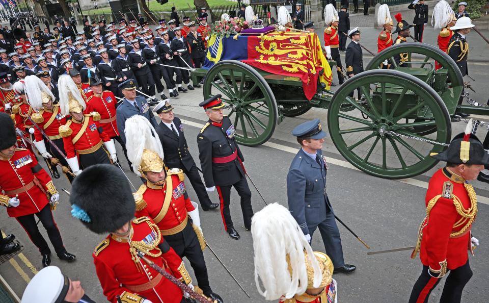 The State Gun Carriage carries the coffin of Queen Elizabeth II, draped in the Royal Standard with the Imperial State Crown and the Sovereign's orb and sceptre, as it makes its way for the State Funeral at Westminster Abbey, London on September 19, 2022. (Photo by Marc Aspland / POOL / AFP) (Photo by MARC ASPLAND/POOL/AFP via Getty Images)