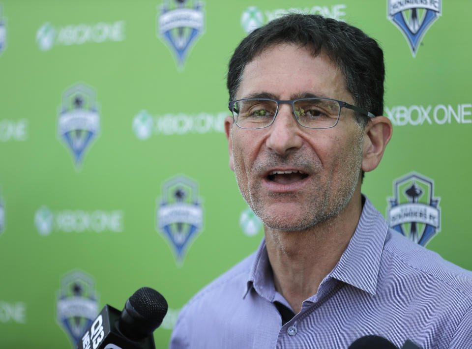 FILE - In this Aug. 29, 2018, file photo, MLS soccer Seattle Sounders majority owner Adrian Hanauer talks to reporters in Tukwila, Wash. The Sounders announced Tuesday, Aug. 13, 2019, that they are adding Seattle Seahawks quarterback Russell Wilson and several others to the club's ownership group, as Hollywood producer Joe Roth leaves the franchise. (AP Photo/Ted S. Warren, File)