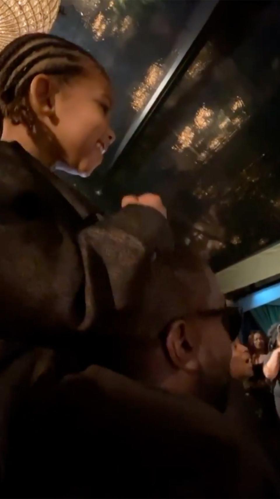 Kim's son, Saint, sat on his dad's shoulders to get a better view of the performers. 