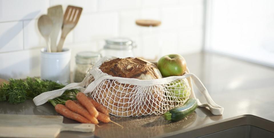 fresh bread organic vegetables and fruit on a plastic free zero waste kitchen worktop