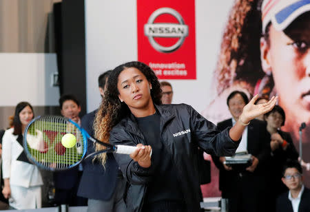 U.S. Open tennis champion Naomi Osaka hits a ball to Nissan Motor's Senior Vice President Asako Hoshino after a contract signing ceremony at Nissan's global headquarters in Yokohama, Japan, September 13, 2018. REUTERS/Toru Hanai