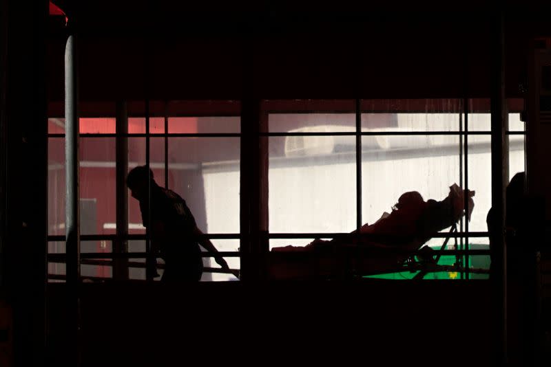 A paramedic wheels a patient into Elmhurst Hospital during outbreak of coronavirus disease (COVID-19) in New York