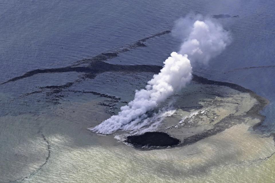 This aerial photo shows steam billowing from the waters off Iwoto Island, Ogasawara town in the Pacific Ocean, southern Tokyo, on Oct. 30, 2023. A new island, 100 meters in diameter, formed by erupted rock, is seen near the steam, according to Kyodo News. (Kyodo News via AP)