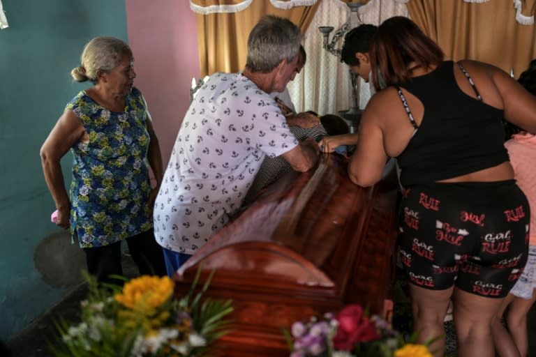 Familiares de Víctor Alfonzo Bustos, de 35 años, lloran su muerte sobre su ataúd durante el velorio en su casa en Valencia, estado Carabobo, Venezuela, el 31 de julio de 2024 (Yuri CORTEZ)