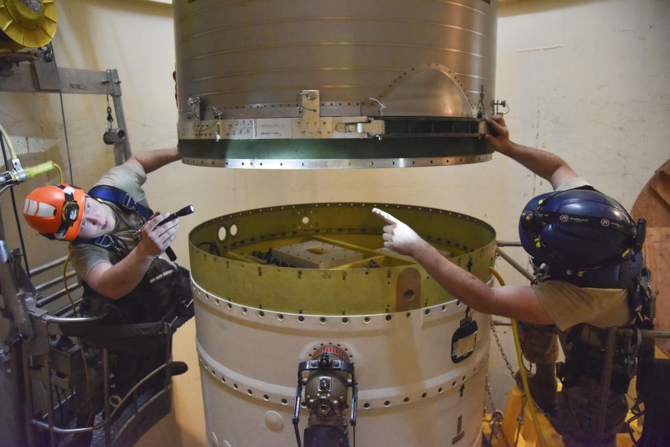 In this image provided by the U.S. Air Force, Airman 1st Class Jackson Ligon, left, and Senior Airman Jonathan Marinaccio, 341st Missile Maintenance Squadron technicians connect a re-entry system to a spacer on an intercontinental ballistic missile during a Simulated Electronic Launch-Minuteman test Sept. 22, 2020, at a launch facility near Malmstrom Air Force Base in Great Falls, Mont. The top Air Force officer in charge of the nation's air and ground-launched nuclear missiles has requested an official investigation into the number of officers who are reporting the same type of blood cancer after serving at Malmstrom Air Force Base. (Senior Airman Daniel Brosam/U.S. Air Force via AP)