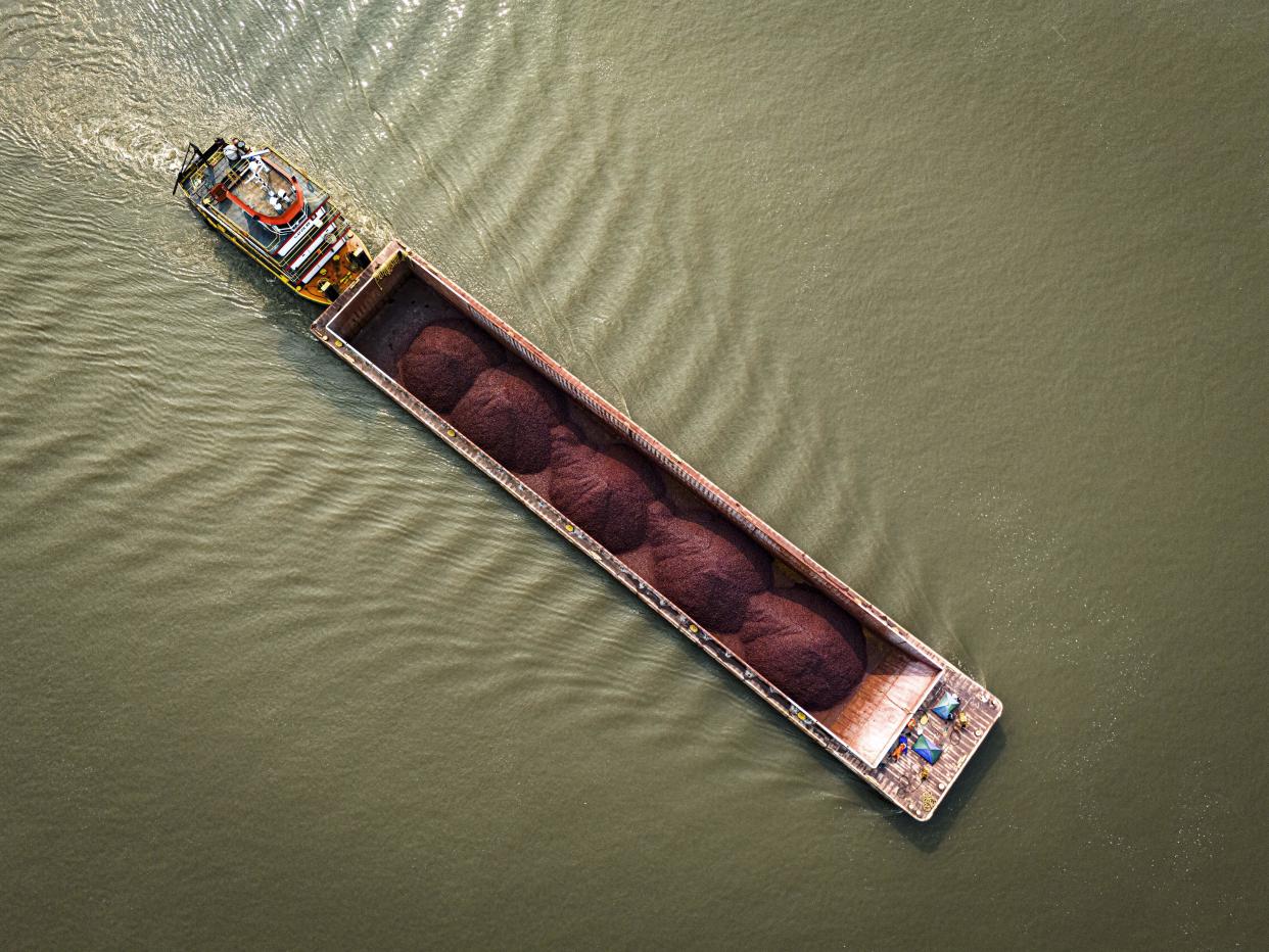 A tugboat pushes a barge with a light load across the Paraguay River amid a drought and low water levels in Mariano Roque Alonso, Paraguay, Monday, Sept. 9, 2024. (AP Photo/Jorge Saenz)