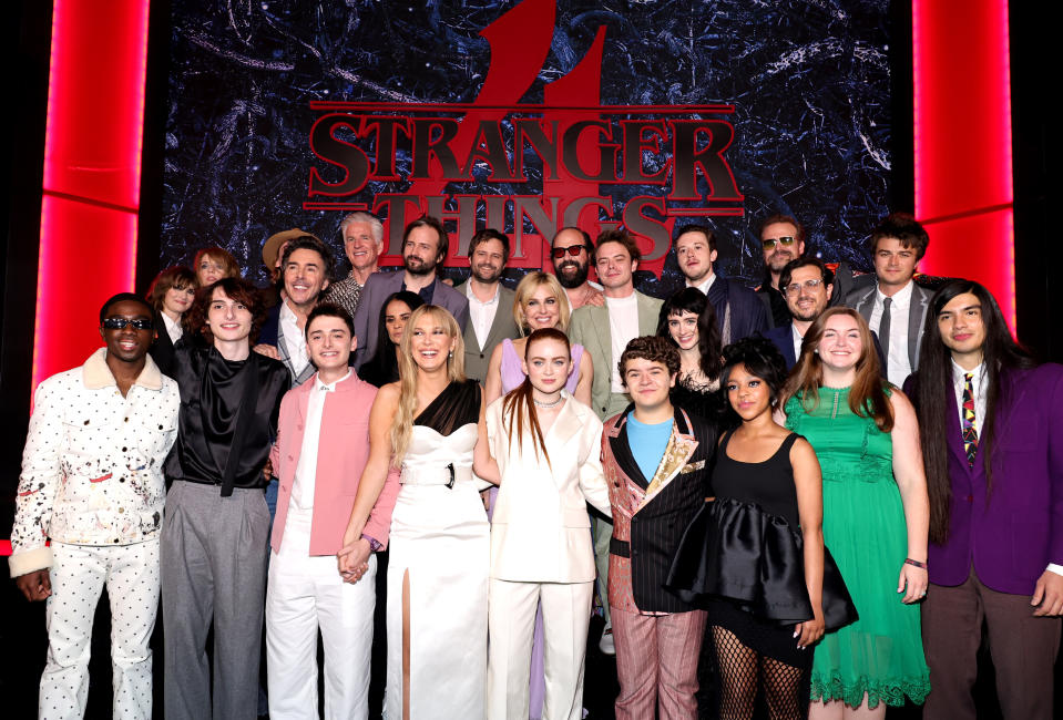 Group of "Stranger Things" cast members standing together in an event, dressed in formal attire