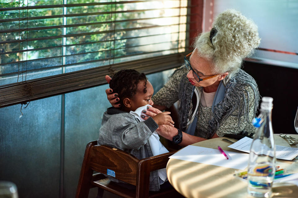 a woman with a baby in a high chair at a restaurant