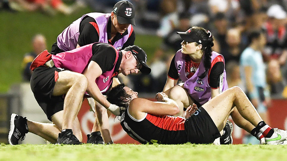 St Kilda's Hunter Clark is attended to by trainers after a collision with Adelaide's David Mackay.