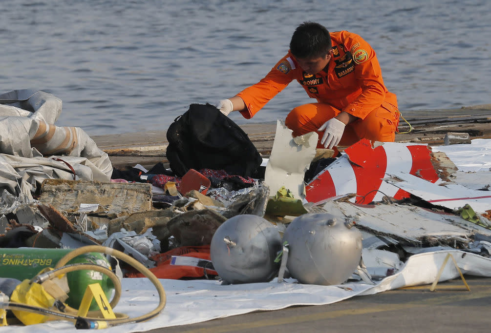 A rescue worker inspects debris believed to be from the Lion Air passenger jet that crashed into the sea off Jakarta (Picture: AP)