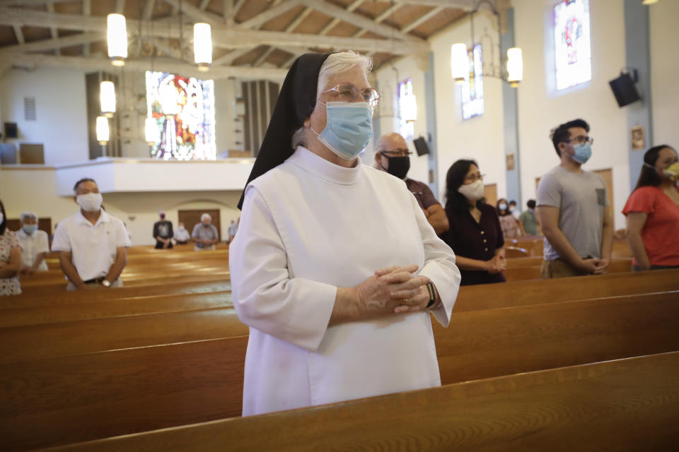 A nun wears a face mask during a service at the San Gabriel Mission, Sunday, July 12, 2020, in San Gabriel, Calif., amid the coronavirus pandemic. A fire on Saturday destroyed the rooftop and most of the interior of the nearly 250-year-old California church that was undergoing renovation. (AP Photo/Marcio Jose Sanchez)