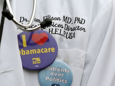 Dr. Tom Ellison of Birmingham, Alabama wears a stethoscope and pro-affordable healthcare buttons, during a demonstration in front of the Supreme Court in Washington March 4, 2015. REUTERS/Gary Cameron