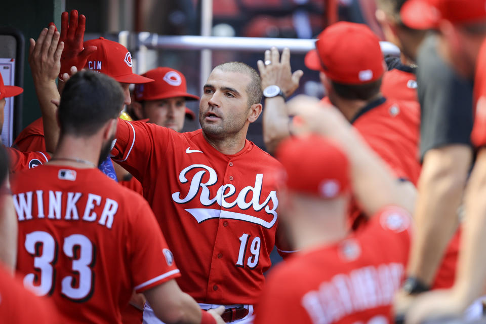 Cincinnati Reds' Joey Votto high-fives teammates after hitting a solo home run during the fourth inning of a baseball game against the Chicago Cubs in Cincinnati, Saturday, July 3, 2021. (AP Photo/Aaron Doster)
