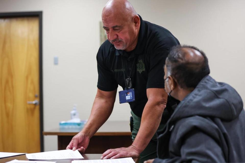 Deputy Constable Ruben Hernandez helps a landlord find a document during an eviction court hearing in downtown Fort Worth. Hernandez and Judge Sergio De Leon spoke with the landlord in Spanish during the hearing.