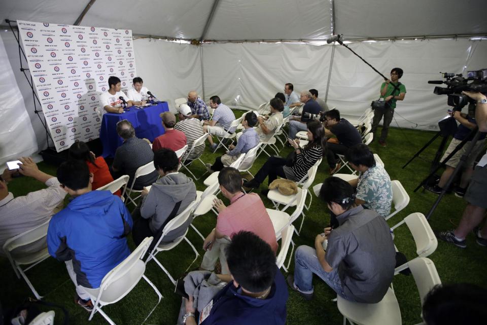 Texas Rangers' Yu Darvish, left at the table, of Japan, speaks during a news conference at baseball spring training, Tuesday, Feb. 18, 2014, in Surprise, Ariz. (AP Photo/Tony Gutierrez)