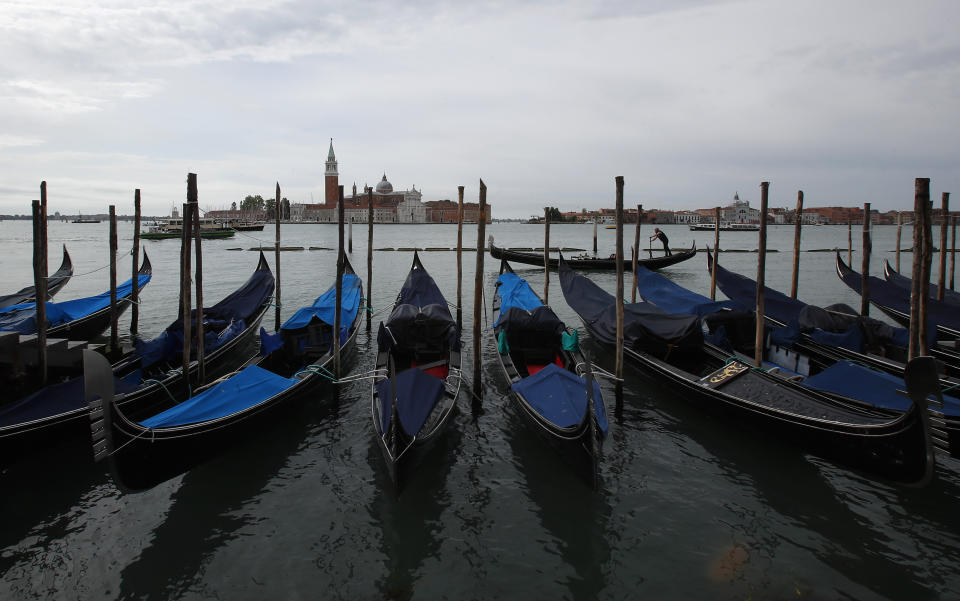 In this picture taken on Wednesday, May 13, 2020, gondolas are moored at the Canal grande (Grand Canal) in Venice, Italy. Venetians are rethinking their city in the quiet brought by the coronavirus pandemic. For years, the unbridled success of Venice's tourism industry threatened to ruin the things that made it an attractive destination to begin with. Now the pandemic has ground to a halt Italy’s most-visited city, stopped the flow of 3 billion euros in annual tourism-related revenue and devastated the city's economy. (AP Photo/Antonio Calanni)