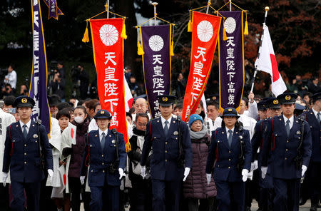 Well-wishers carrying flags are led by Imperial Guard officers as they gather to celebrate Japan's Emperor Akihito's 85th birthday at the Imperial Palace in Tokyo, Japan, December 23, 2018. REUTERS/Issei Kato