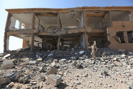 A soldier loyal to Yemen's President Abd-Rabbu Mansour Hadi walks past a destroyed building at the Mass army barracks after the pro-Hadi forces took it from Houthi rebels in the country's northwestern province of Marib December 18, 2015. REUTERS/Ali Owidha