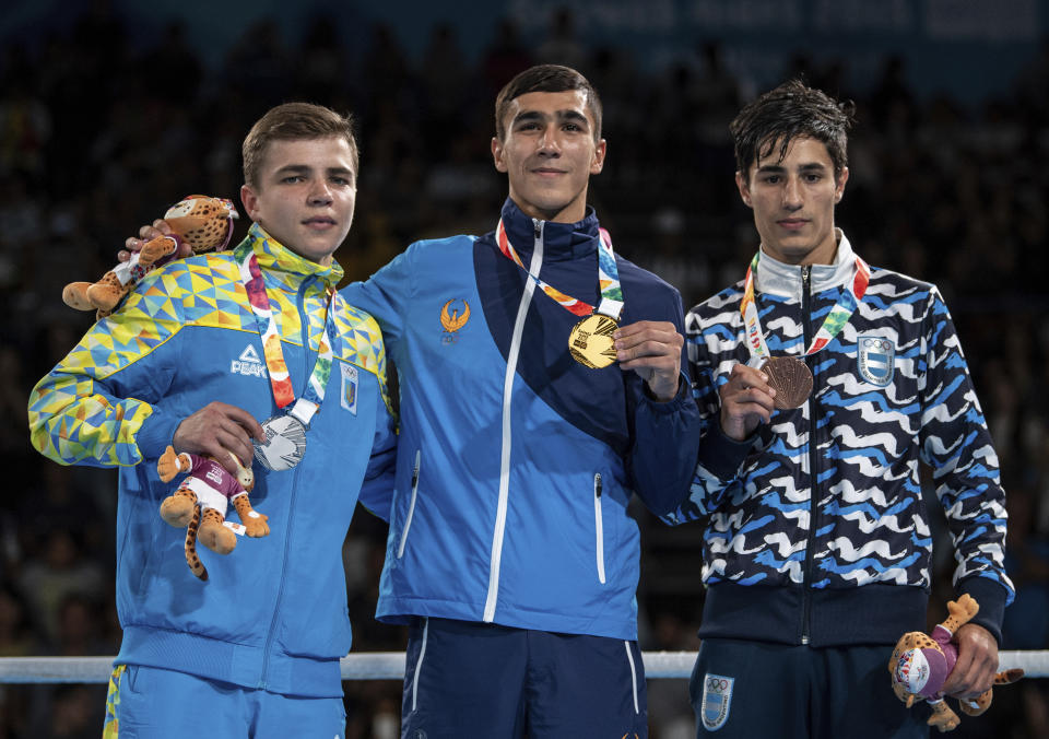 In this photo provided by the International Olympic Committee, from left, silver medalist Maksym Halinichev of Ukraine, gold medalist Abdumalik Khalokov of Uzbekistan and bronze medalist Mirco Jehiel Cuello of Argentina stand together during the medal ceremony for the Boxing Mens Bantam (up to 56kg) during The Youth Olympic Games in Buenos Aires, Thursday, Oct. 18, 2018. Halinichev considered the bout a loss – it wasn’t gold, after all – but it gave him a map for the future. (Thomas Lovelock/IOC via AP)