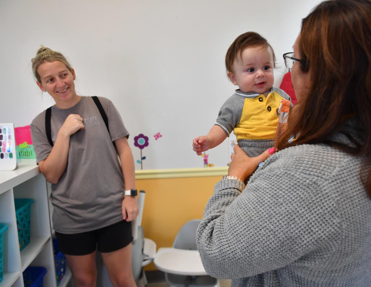 Becca Foy of Palmetto, left, drops her son, Zander, 6 months, off with Laurie McCracken, right, at the new Baby Fox Academy childcare in Lakewood Ranch on Tuesday, July 12, 2022.  McCracken, owner and executive director of Baby Fox Academy in Sarasota, opened a new childcare location in Lakewood Ranch in the first week of July and is already at fifty-percent capacity. 