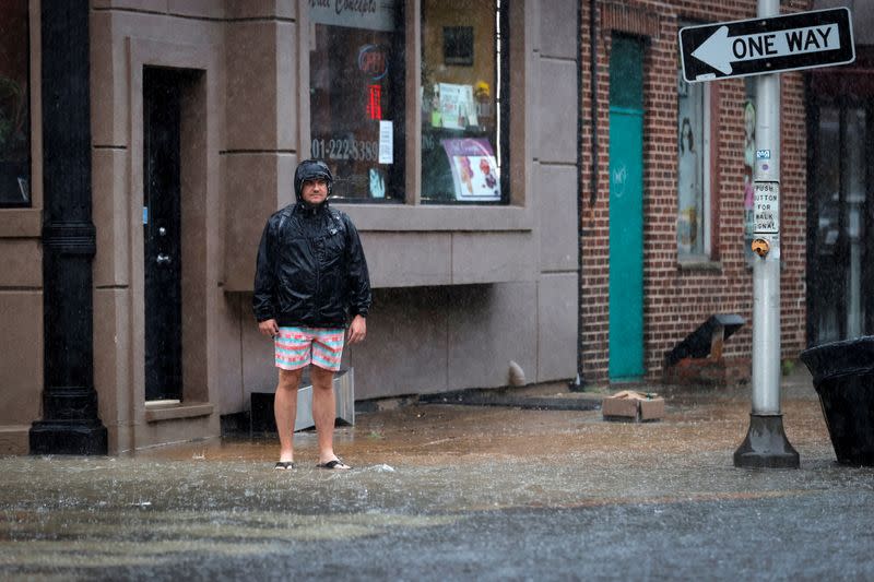 A man stands in a flooded street as Tropical Storm Fay sweeps across the heavily populated northeastern United States in Hoboken