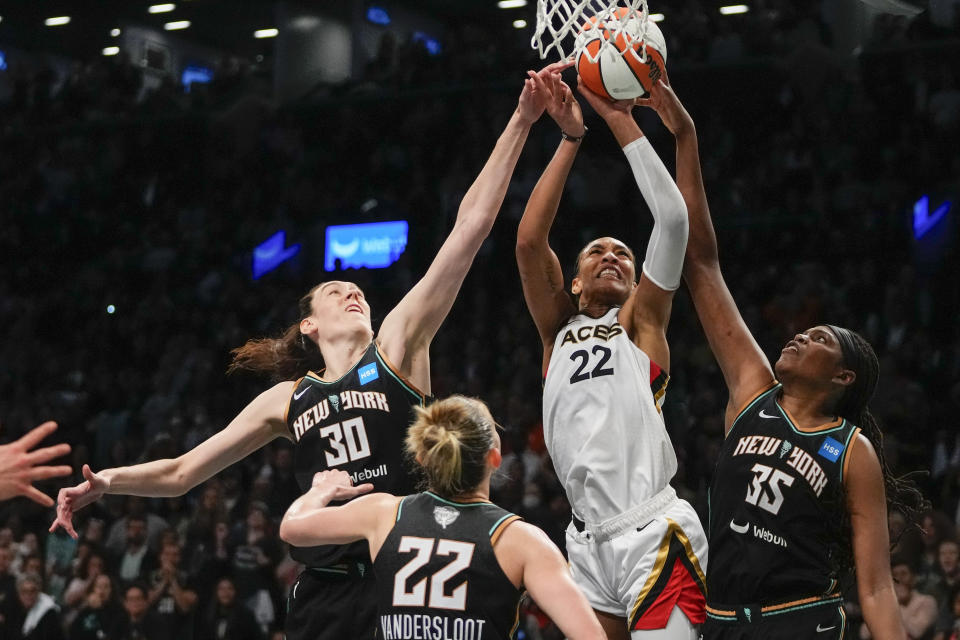 New York Liberty's Jonquel Jones (35), Courtney Vandersloot (22) and Breanna Stewart (30) defend a shot by Las Vegas Aces' A'ja Wilson (22) during the second half in Game 4 of a WNBA basketball final playoff series Wednesday, Oct. 18, 2023, in New York. The Aces won 70-69. (AP Photo/Frank Franklin II)