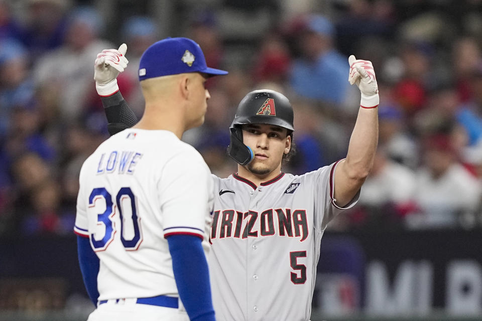 Arizona Diamondbacks' Alek Thomas celebrates a single as Texas Rangers first baseman Nathaniel Lowe looks on during the third inning in Game 2 of the baseball World Series Saturday, Oct. 28, 2023, in Arlington, Texas. (AP Photo/Brynn Anderson)