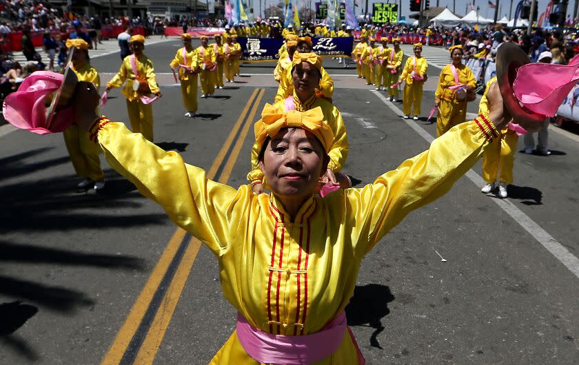 Los Angeles, CA - Members of a group called Falun Dafa perform on Main Street during the Huntington Beach Independence Day Parade on July 4, 2023. Thousands of people gathered in the Orange County coastal community for the annual ecvent. July 04: in Los Angeles on Tuesday, July 4, 2023 in Los Angeles, CA. (Luis Sinco / Los Angeles Times)