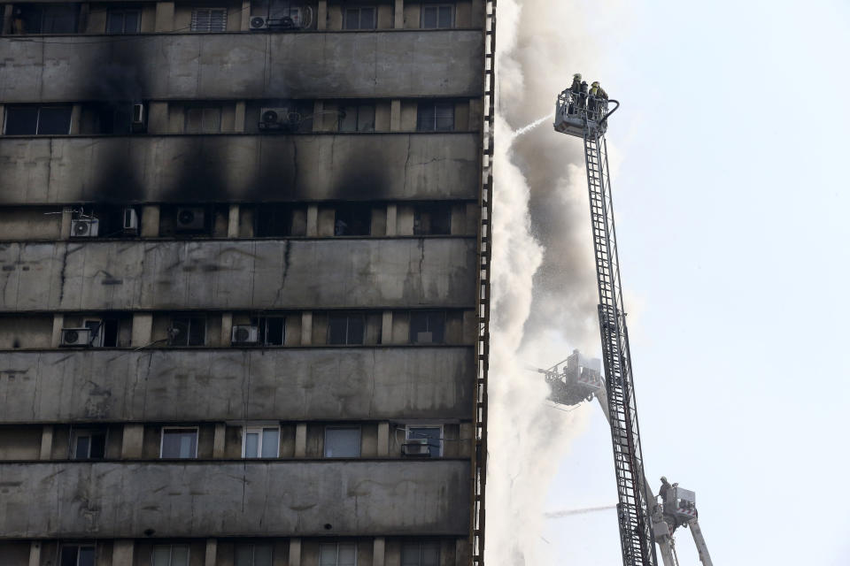 Iranian firefighters work to extinguish fire of the Plasco building in central Tehran, Iran, Thursday, Jan. 19, 2017. A high-rise building in Tehran engulfed by a fire collapsed on Thursday as scores of firefighters battled the blaze. (AP Photo/Vahid Salemi)