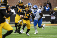 Missouri quarterback Brady Cook center, runs from Kentucky defensive tackle Octavious Oxendine, right, during the second quarter of an NCAA college football game Saturday, Nov. 5, 2022, in Columbia, Mo. (AP Photo/L.G. Patterson)