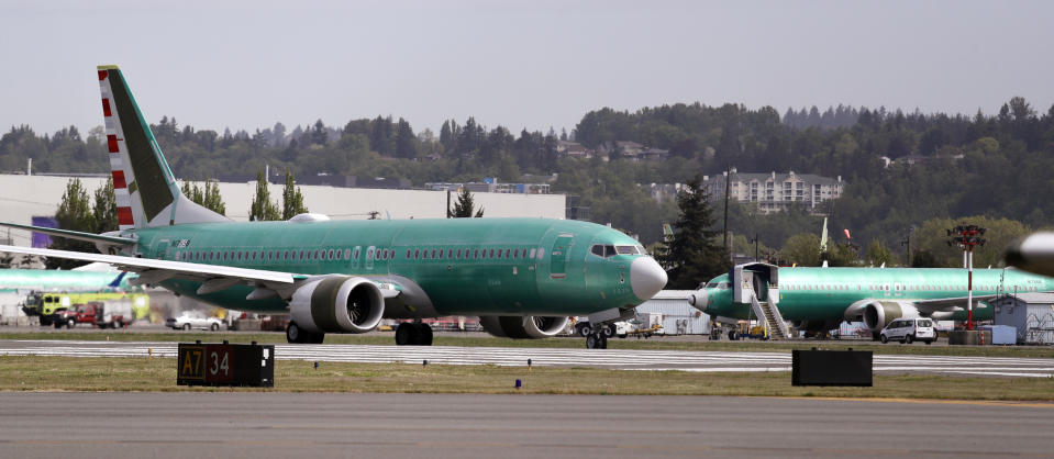 FILE - In this May 8, 2019, file photo a Boeing 737 MAX 8, being built for American Airlines, rolls down the runway and past another jet of the same model as it's prepared for takeoff on a test flight in Renton, Wash. United Airlines said Friday, July 12, that it now expects to cancel more than 8,000 flights through October because of the grounding of its Boeing 737 Max planes. (AP Photo/Elaine Thompson, File)
