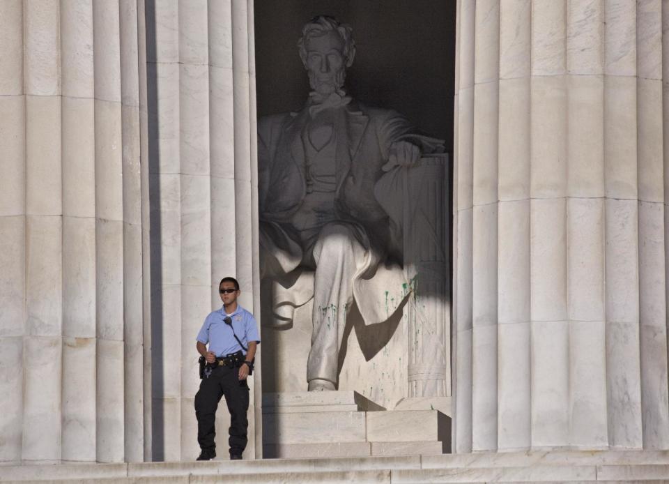 U.S. Park Police close off the Lincoln Memorial to visitors after someone splattered green paint on the statue and the floor area, in Washington, Friday, July 26, 2013. Police say the apparent vandalism was discovered early Friday morning. No words, letters or symbols were visible in the paint. (AP Photo/J. Scott Applewhite)