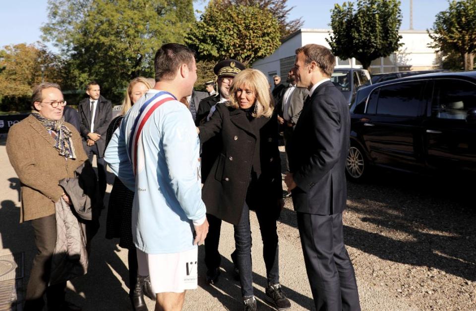 President Emmanuel Macron and First Lady Brigitte Macron arrive at the Leo Lagrange stadium in Poissy for a charity football match in aid of the Fondation Hopitaux de Paris-Hopitaux de France in Poissy on October 14. - Credit: AP