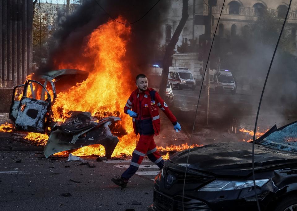 A medical worker walks near a burned car after Russian military strike, as Russia's invasion of Ukraine continues (REUTERS)