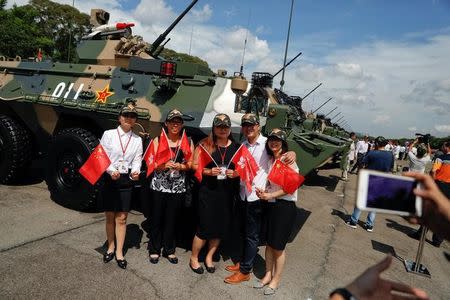 People have their picture taken in front of armoured vehicles after Chinese President Xi Jinping (unseen) inspected troops at the People's Liberation Army (PLA) Hong Kong Garrison in one of events marking the 20th anniversary of the city's handover from British to Chinese rule, in Hong Kong, China June 30, 2017. REUTERS/Damir Sagolj